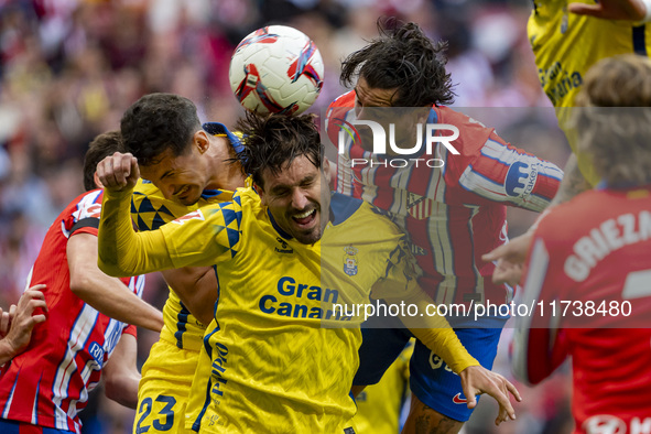 Jose Gimenez of Atletico de Madrid (C) fights for the ball against Alex Munoz (L) and Jose Gomez Campana (R) of UD Las Palmas during the La...