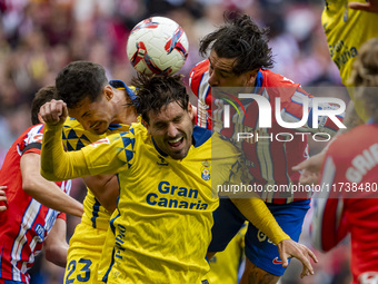 Jose Gimenez of Atletico de Madrid (C) fights for the ball against Alex Munoz (L) and Jose Gomez Campana (R) of UD Las Palmas during the La...