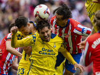 Jose Gimenez of Atletico de Madrid (C) fights for the ball against Alex Munoz (L) and Jose Gomez Campana (R) of UD Las Palmas during the La...