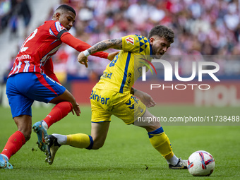 Victor Alvarez Rozada (Viti) of UD Las Palmas competes for the ball against Samuel Lino of Atletico de Madrid during the La Liga EA Sports 2...