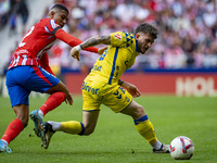 Victor Alvarez Rozada (Viti) of UD Las Palmas competes for the ball against Samuel Lino of Atletico de Madrid during the La Liga EA Sports 2...