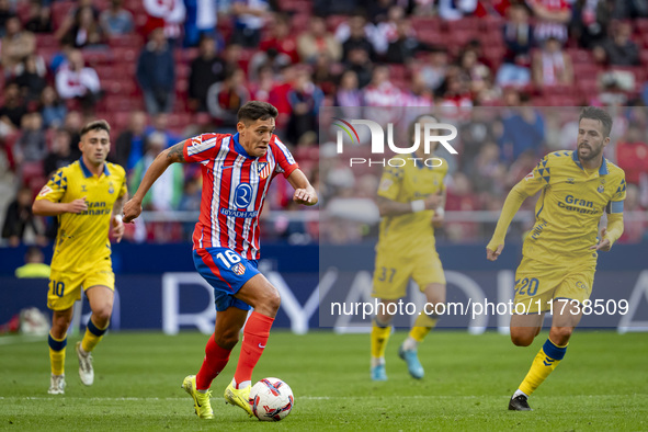 Nahuel Molina of Atletico de Madrid is in action with the ball among players of UD Las Palmas (from L to R) Alberto Moleiro, Fabio Silva, an...