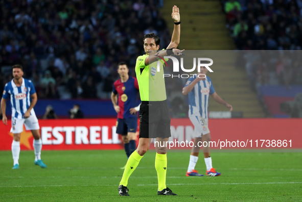 The referee Jose Luis Munuera Montero officiates the match between FC Barcelona and RCD Espanyol, corresponding to week 12 of LaLiga EA Spor...