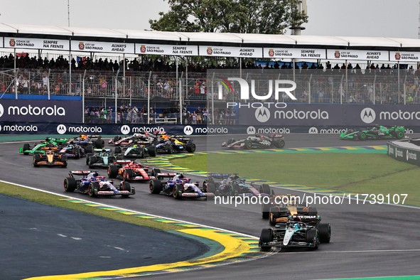 George Russell of the UK drives the (63) Mercedes-AMG Petronas F1 Team F1 W15 E Performance Mercedes and leads the group at the start of the...