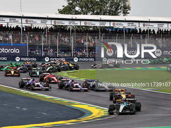 George Russell of the UK drives the (63) Mercedes-AMG Petronas F1 Team F1 W15 E Performance Mercedes and leads the group at the start of the...