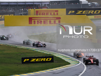 Charles Leclerc of Monaco drives the (16) Scuderia Ferrari SF-24 Ferrari and leads the group during the Formula 1 Lenovo Grande Premio De Sa...