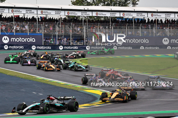 George Russell of the UK drives the (63) Mercedes-AMG Petronas F1 Team F1 W15 E Performance Mercedes and leads the group at the start of the...