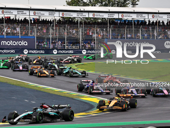 George Russell of the UK drives the (63) Mercedes-AMG Petronas F1 Team F1 W15 E Performance Mercedes and leads the group at the start of the...