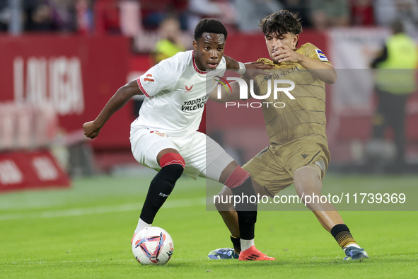 In Seville, Spain, on November 3, 2024, Idumbo of Sevilla FC competes for the ball with Jon Aramburu of Real Sociedad during the La Liga EA...