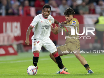 In Seville, Spain, on November 3, 2024, Idumbo of Sevilla FC competes for the ball with Jon Aramburu of Real Sociedad during the La Liga EA...