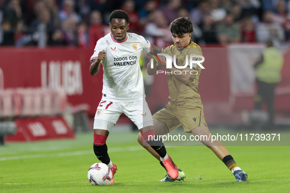 In Seville, Spain, on November 3, 2024, Idumbo of Sevilla FC competes for the ball with Jon Aramburu of Real Sociedad during the La Liga EA...