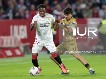 In Seville, Spain, on November 3, 2024, Idumbo of Sevilla FC competes for the ball with Jon Aramburu of Real Sociedad during the La Liga EA...