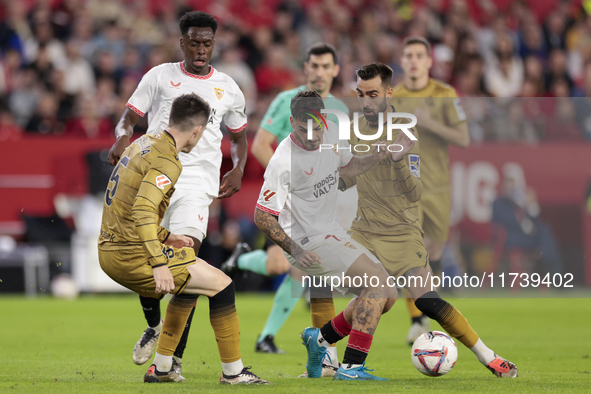 Isaac Romero of Sevilla FC competes for the ball with Brais Mendez of Real Sociedad during the La Liga EA Sports match between Sevilla FC an...