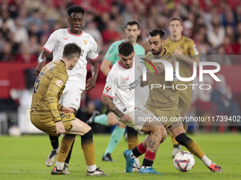 Isaac Romero of Sevilla FC competes for the ball with Brais Mendez of Real Sociedad during the La Liga EA Sports match between Sevilla FC an...