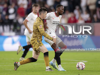 Dodi Lukebakio of Sevilla FC competes for the ball with Igor Zubeldia of Real Sociedad during the La Liga EA Sports match between Sevilla FC...