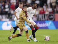 Dodi Lukebakio of Sevilla FC competes for the ball with Igor Zubeldia of Real Sociedad during the La Liga EA Sports match between Sevilla FC...