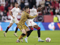 Dodi Lukebakio of Sevilla FC competes for the ball with Igor Zubeldia of Real Sociedad during the La Liga EA Sports match between Sevilla FC...