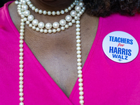 A woman wears a button that says ''Teachers for Harris Walz'' at a Get Out the Vote event in Harrisburg, Pennsylvania, United States, on Nov...