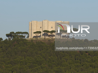 A panoramic shot captures the iconic Castel del Monte from afar, situated on a hill in the Apulian countryside. This UNESCO World Heritage s...