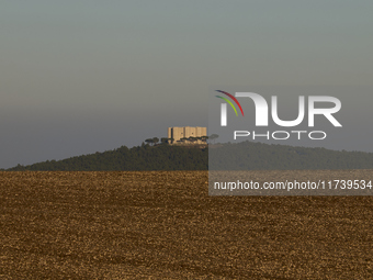 A panoramic shot captures the iconic Castel del Monte from afar, situated on a hill in the Apulian countryside. This UNESCO World Heritage s...