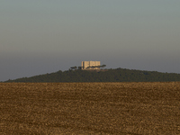 A panoramic shot captures the iconic Castel del Monte from afar, situated on a hill in the Apulian countryside. This UNESCO World Heritage s...