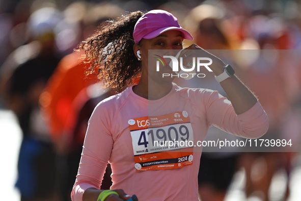 Runner Yiciana Rodriguez of the United States receives a refreshment as she heads up First Avenue during the 2024 New York City Marathon in...