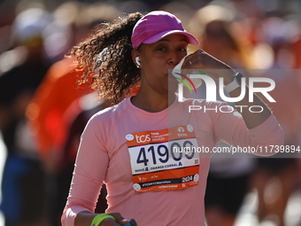 Runner Yiciana Rodriguez of the United States receives a refreshment as she heads up First Avenue during the 2024 New York City Marathon in...