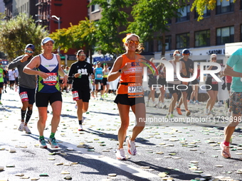 Runner Alexis Herron of the United States smiles at the camera as she heads up First Avenue during the 2024 New York City Marathon in New Yo...