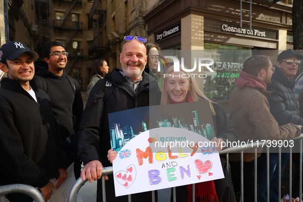 Crowds hold up signs and watch New York City marathon runners as they race up First Avenue in the Upper East Side neighborhood of New York,...