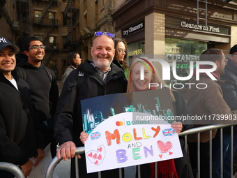 Crowds hold up signs and watch New York City marathon runners as they race up First Avenue in the Upper East Side neighborhood of New York,...