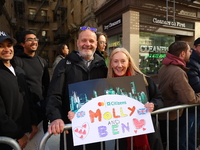 Crowds hold up signs and watch New York City marathon runners as they race up First Avenue in the Upper East Side neighborhood of New York,...