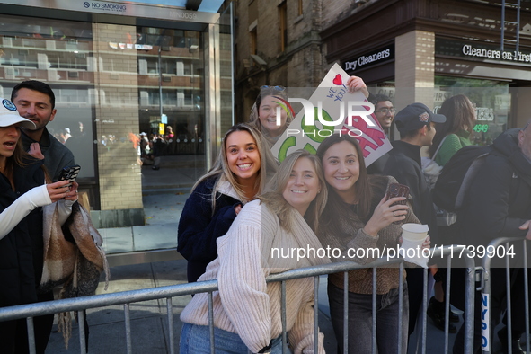 Crowds hold up signs and watch New York City marathon runners as they race up First Avenue in the Upper East Side neighborhood of New York,...