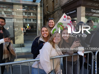 Crowds hold up signs and watch New York City marathon runners as they race up First Avenue in the Upper East Side neighborhood of New York,...