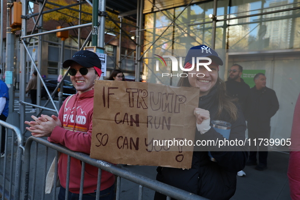 Crowds hold up signs and watch New York City marathon runners as they race up First Avenue in the Upper East Side neighborhood of New York,...