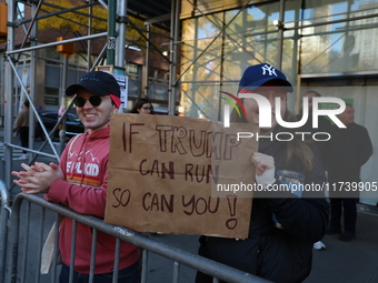 Crowds hold up signs and watch New York City marathon runners as they race up First Avenue in the Upper East Side neighborhood of New York,...