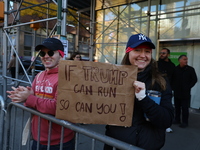 Crowds hold up signs and watch New York City marathon runners as they race up First Avenue in the Upper East Side neighborhood of New York,...