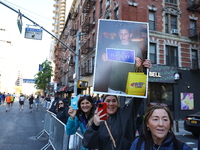 Crowds hold up signs and watch New York City marathon runners as they race up First Avenue in the Upper East Side neighborhood of New York,...