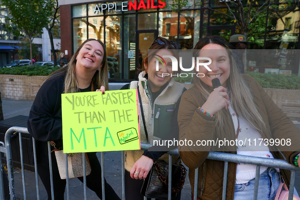 Crowds hold up signs and watch New York City marathon runners as they race up First Avenue in the Upper East Side neighborhood of New York,...