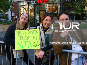 Crowds hold up signs and watch New York City marathon runners as they race up First Avenue in the Upper East Side neighborhood of New York,...