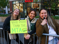 Crowds hold up signs and watch New York City marathon runners as they race up First Avenue in the Upper East Side neighborhood of New York,...