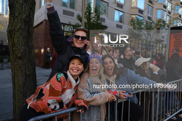 Crowds hold up signs and watch New York City marathon runners as they race up First Avenue in the Upper East Side neighborhood of New York,...