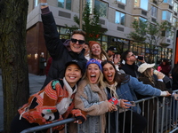 Crowds hold up signs and watch New York City marathon runners as they race up First Avenue in the Upper East Side neighborhood of New York,...