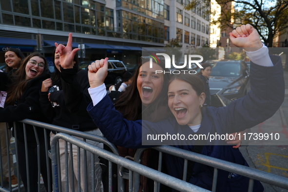 Crowds hold up signs and watch New York City marathon runners as they race up First Avenue in the Upper East Side neighborhood of New York,...