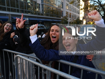 Crowds hold up signs and watch New York City marathon runners as they race up First Avenue in the Upper East Side neighborhood of New York,...