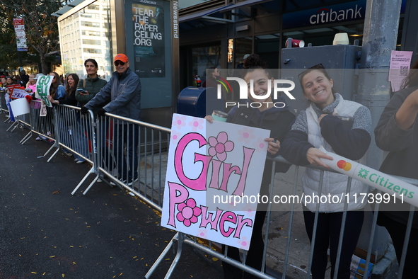 Crowds hold up signs and watch New York City marathon runners as they race up First Avenue in the Upper East Side neighborhood of New York,...