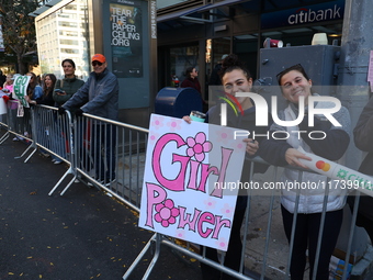 Crowds hold up signs and watch New York City marathon runners as they race up First Avenue in the Upper East Side neighborhood of New York,...