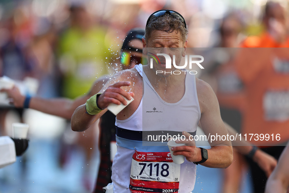 Runner Diarmuid MacDonnell of Ireland splashes himself with water as he runs up First Avenue during the 2024 New York City Marathon in New Y...