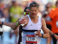 Runner Diarmuid MacDonnell of Ireland splashes himself with water as he runs up First Avenue during the 2024 New York City Marathon in New Y...