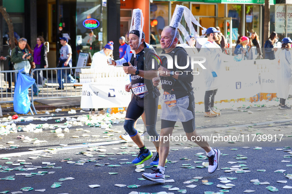 Two runners from France with an interesting headdress run up First Avenue during the 2024 New York City Marathon in New York, N.Y., on Novem...