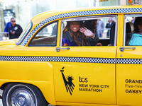 A checkered cab drives Grand Marshall Olympic champion Gabby Thomas up First Avenue during the New York City Marathon in New York City, Unit...